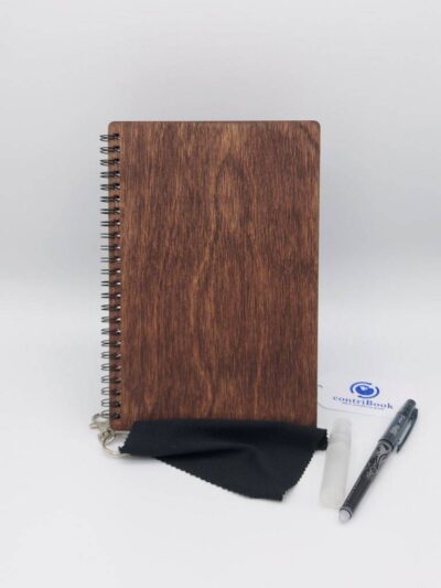 Das Bild zeigt ein Stofftuch, eine Sprühflasche, ein Pilot Frixion Pen und ein wiederverwendbares Notizbuch von contriBook mit hellbraunem Cover aus Holz.